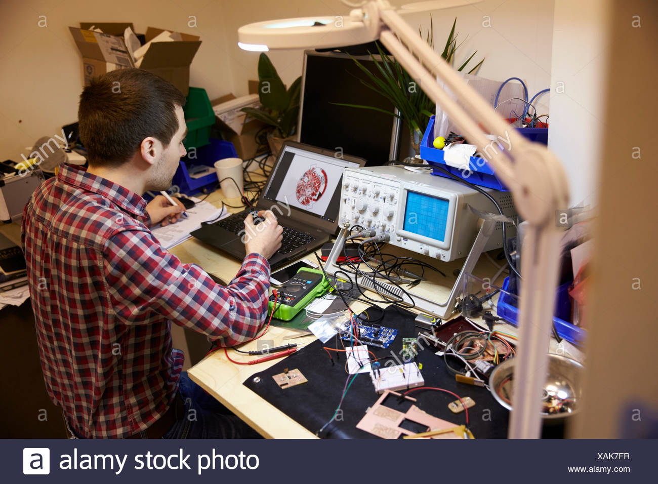 Electrical Engineer Testing Component At Work Bench Stock Photo