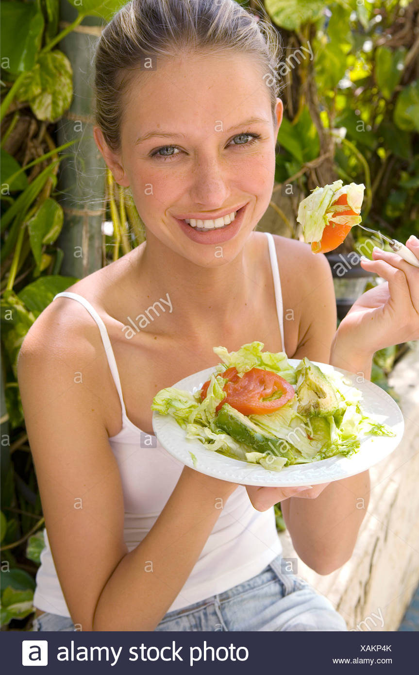 Female Blonde Hair Off Face Wearing White Vest Eating Mixed Salad