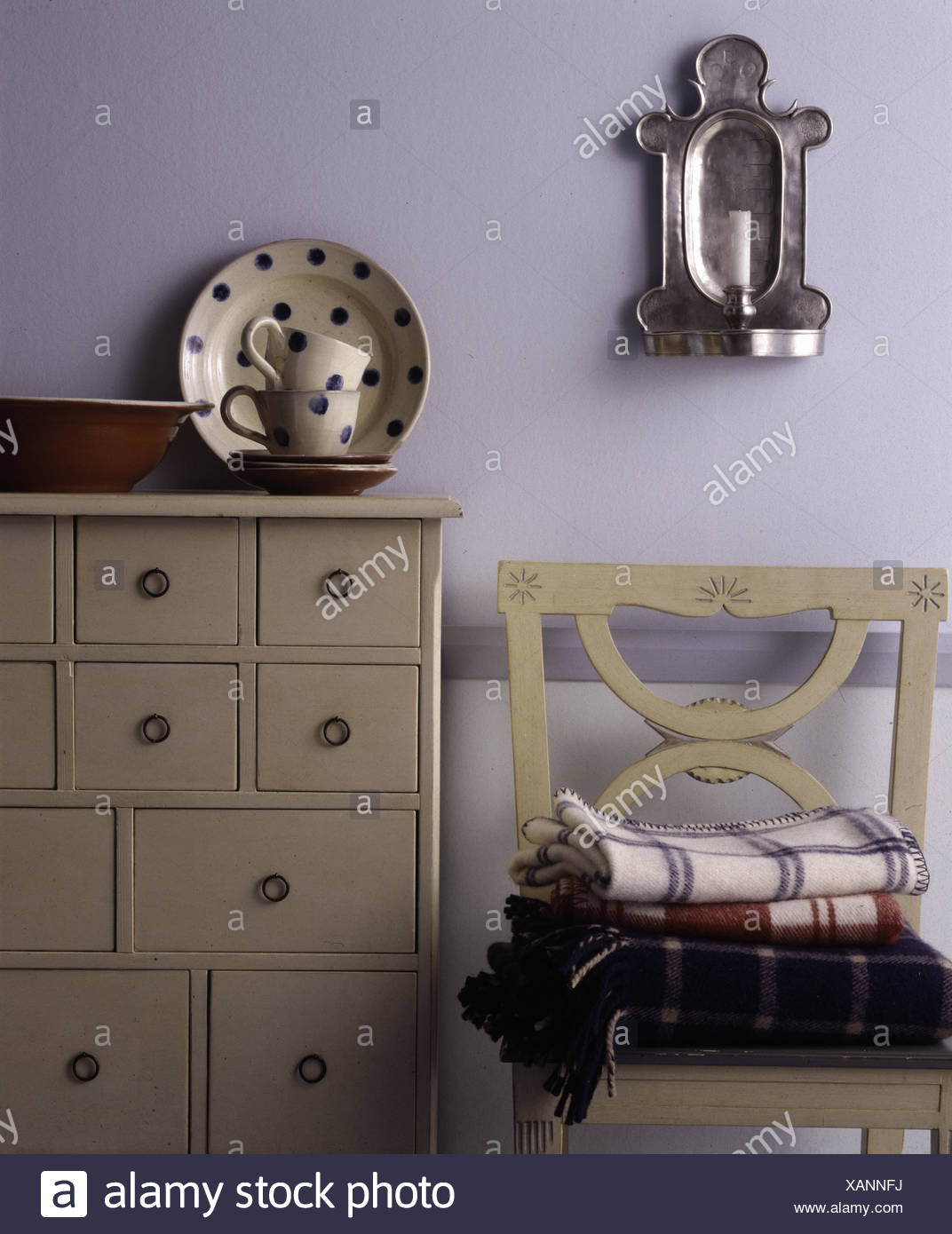 Spotted Crockery On Cream Painted Chest Of Drawers Stock Photo