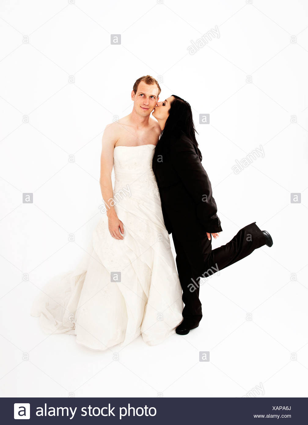Bride Wearing A Suit Kissing A Groom Wearing A Wedding Dress On