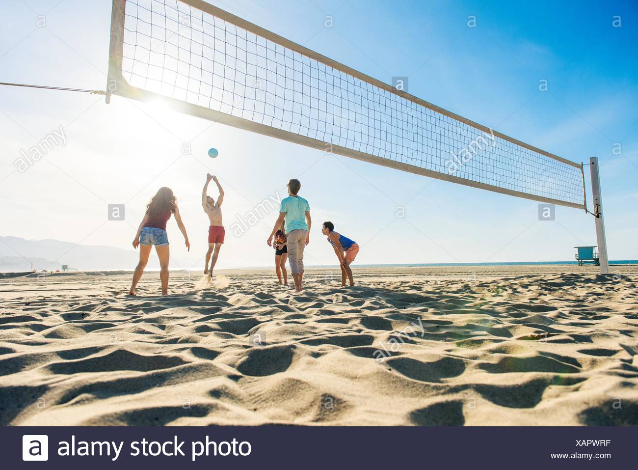 Group of friends playing volleyball on beach Stock Photo