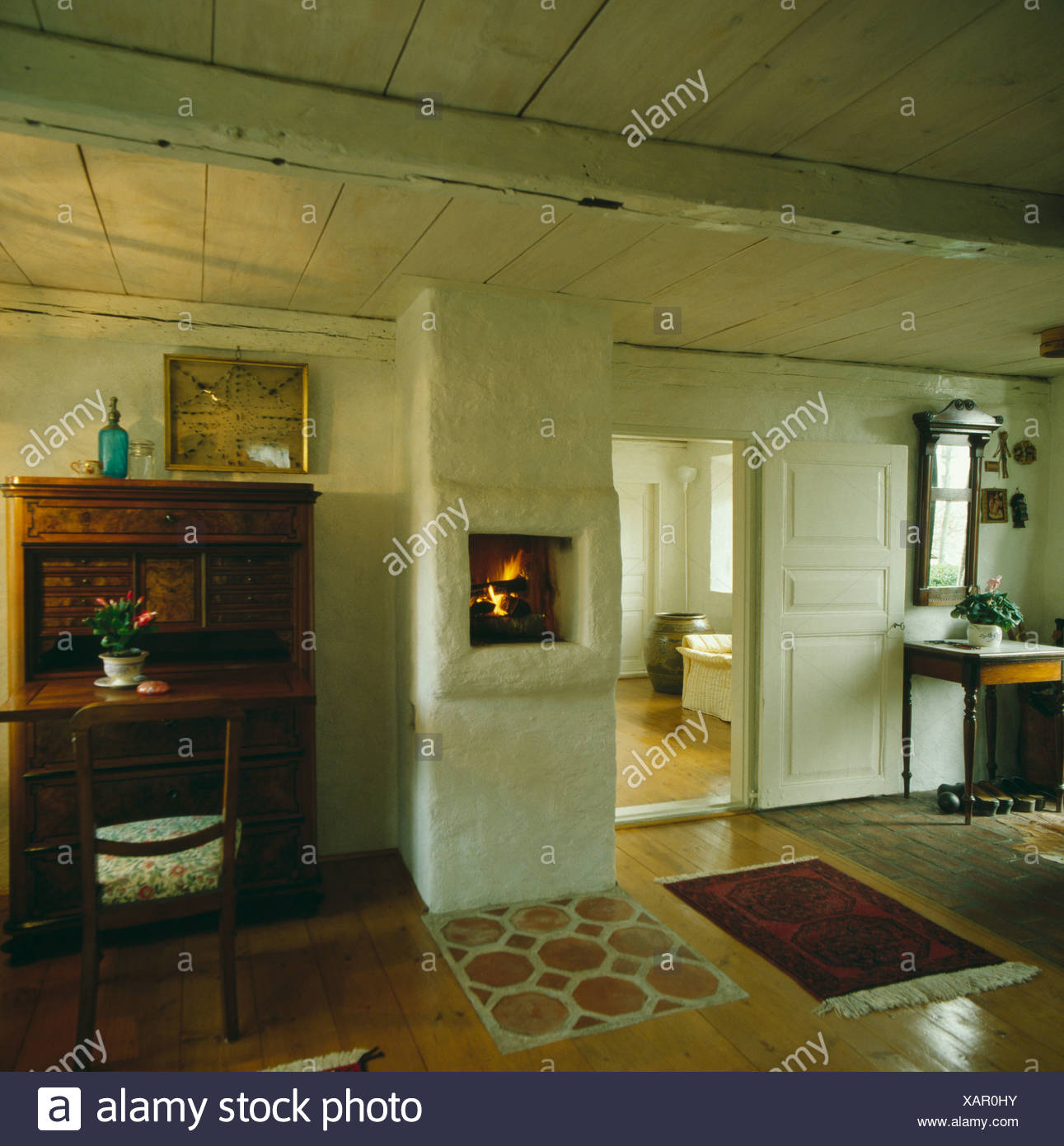 Antique Desk And Wall Mounted Fireplace In Swedish Cottage Hall