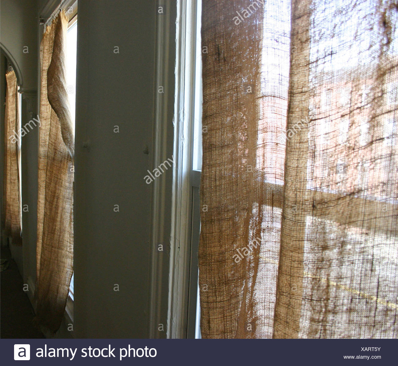 Room With Three Windows And Natural Brown Coloured Curtains In