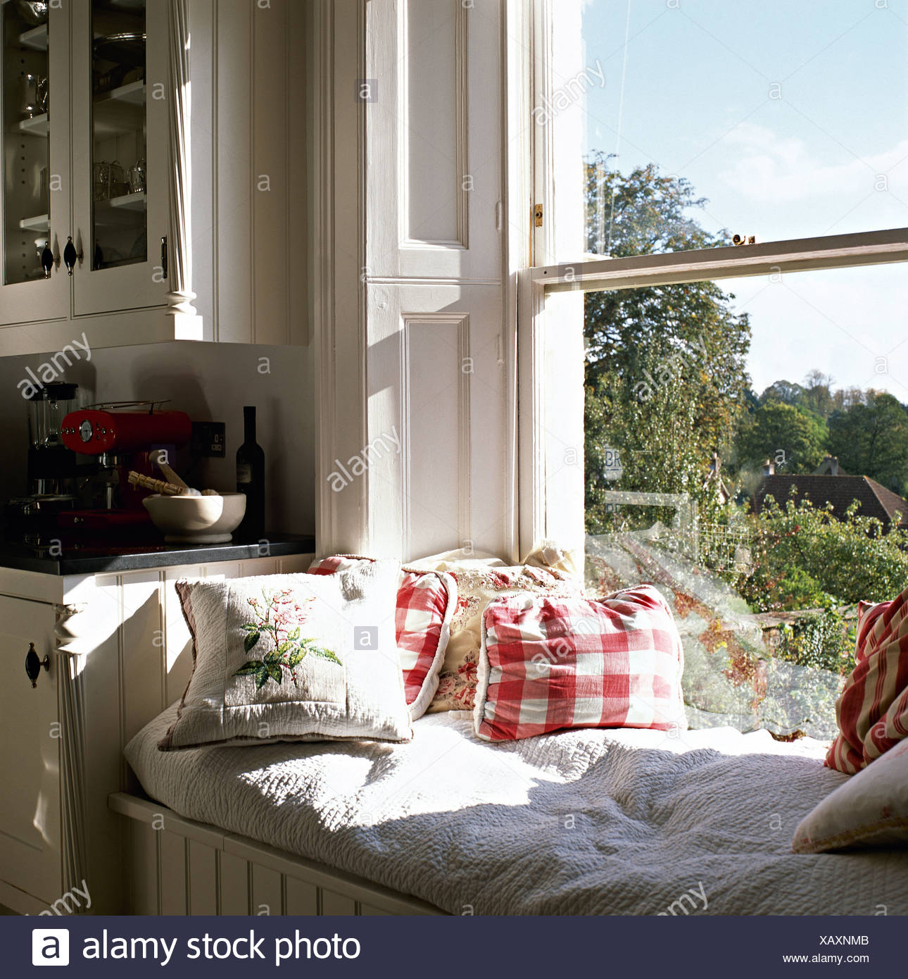 Red Checked Cushions On Sunny Window Seat In Country Kitchen