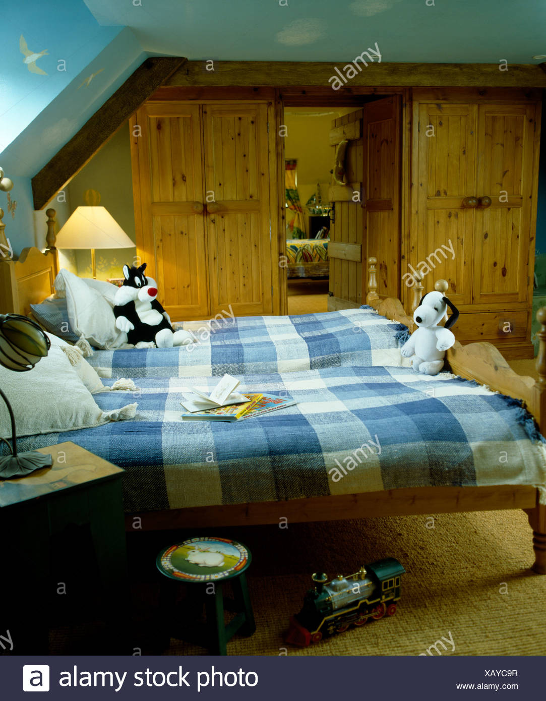 Blue Checked Blankets On Pine Twin Beds In Children S Attic Bedroom With Pine Wardrobes On Either Side Of The Door Stock Photo Alamy