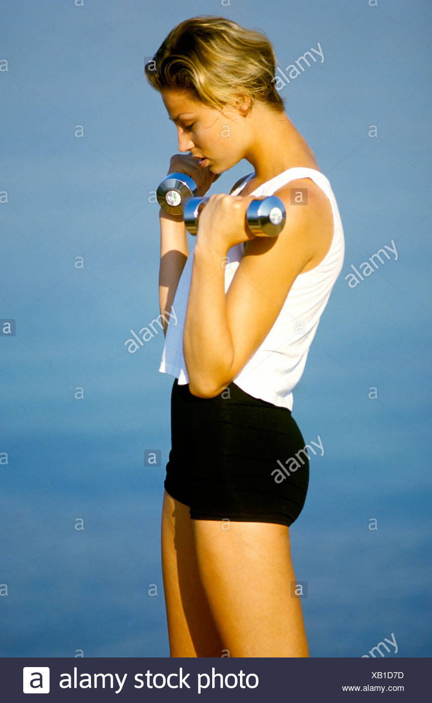 Female With Short Dark Blonde Hair Wearing Black Shorts And White