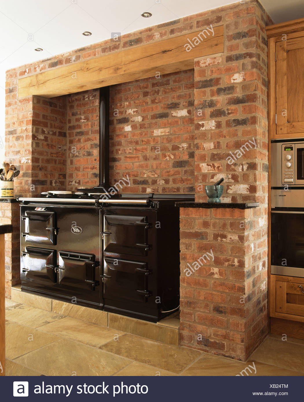 Black Double Aga Oven In Exposed Brick Wall In Country Kitchen