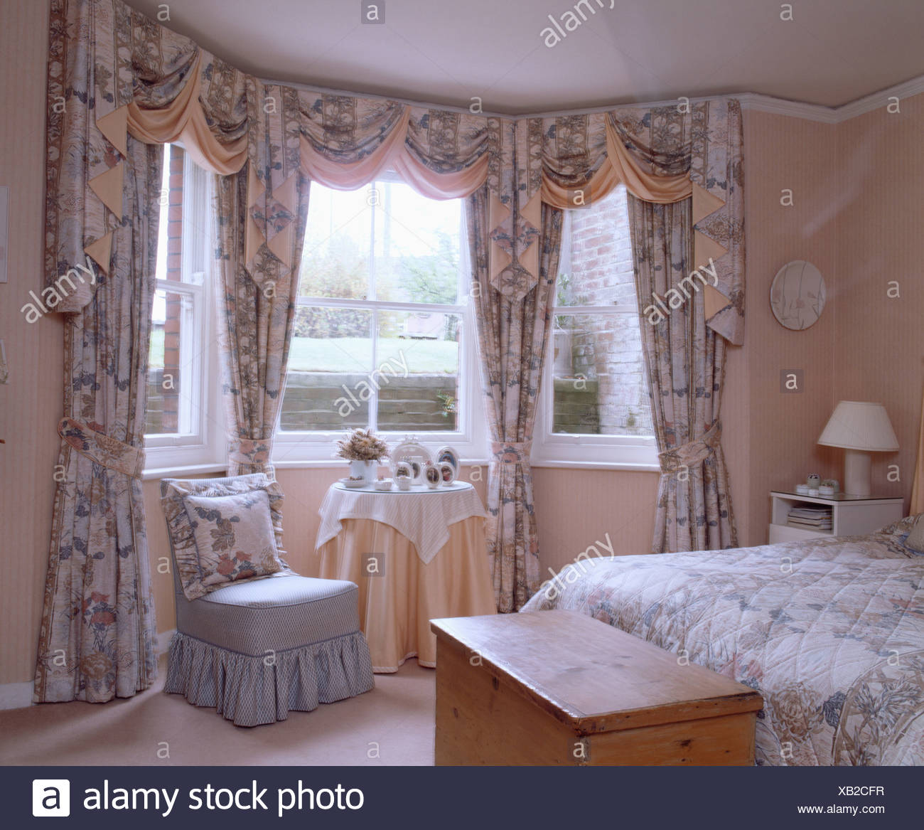 Peach Bedroom With Small Blue Upholstered Chair And Floral