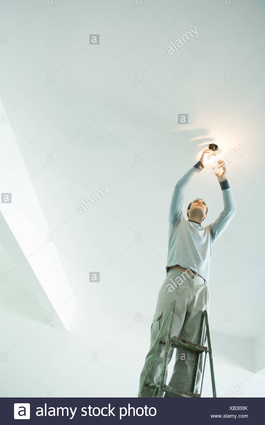 Man Changing Light Bulb On Ladder High Resolution Stock Photography and