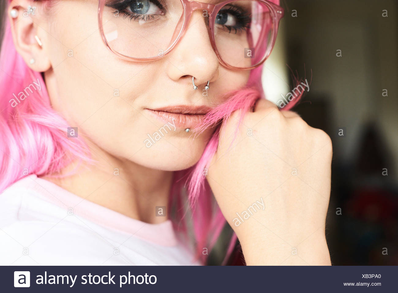 Portrait Of Young Woman With Pink Hair Glasses And Piercings