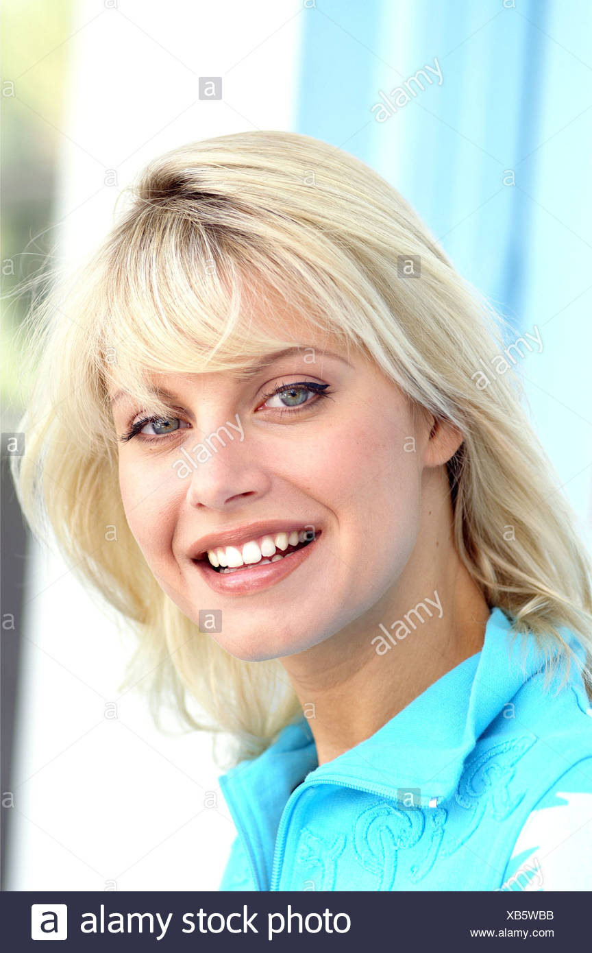 Female With Long Blonde Hair And Fringe Wearing Blue Top With Zip