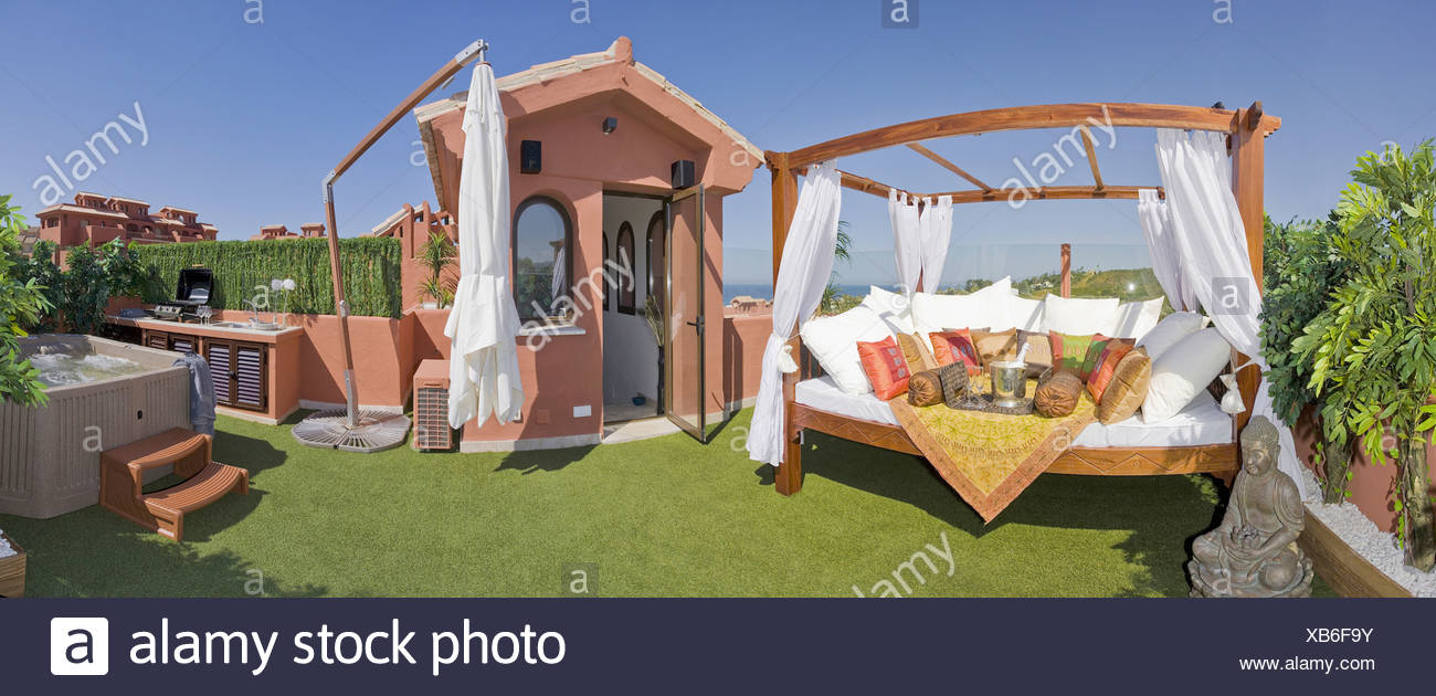 White Cushions On Large Comfy Swing Seat On Roof Garden With Fake