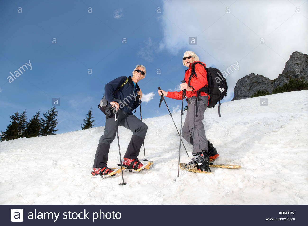 senior couple snowshoeing in mountains Stock Photo