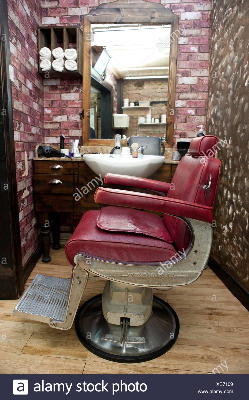 Side View Of Burgundy Leather Chair In Barbershop Stock Photo