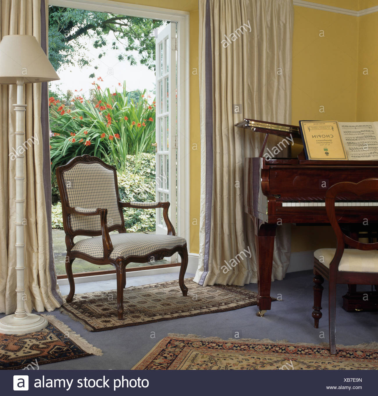 French Style Chair In Front Open French Windows With Cream Drapes