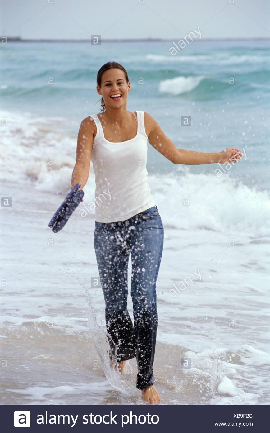 Female Brunette Hair Off Face Wearing White Vest Top And Dark Blue