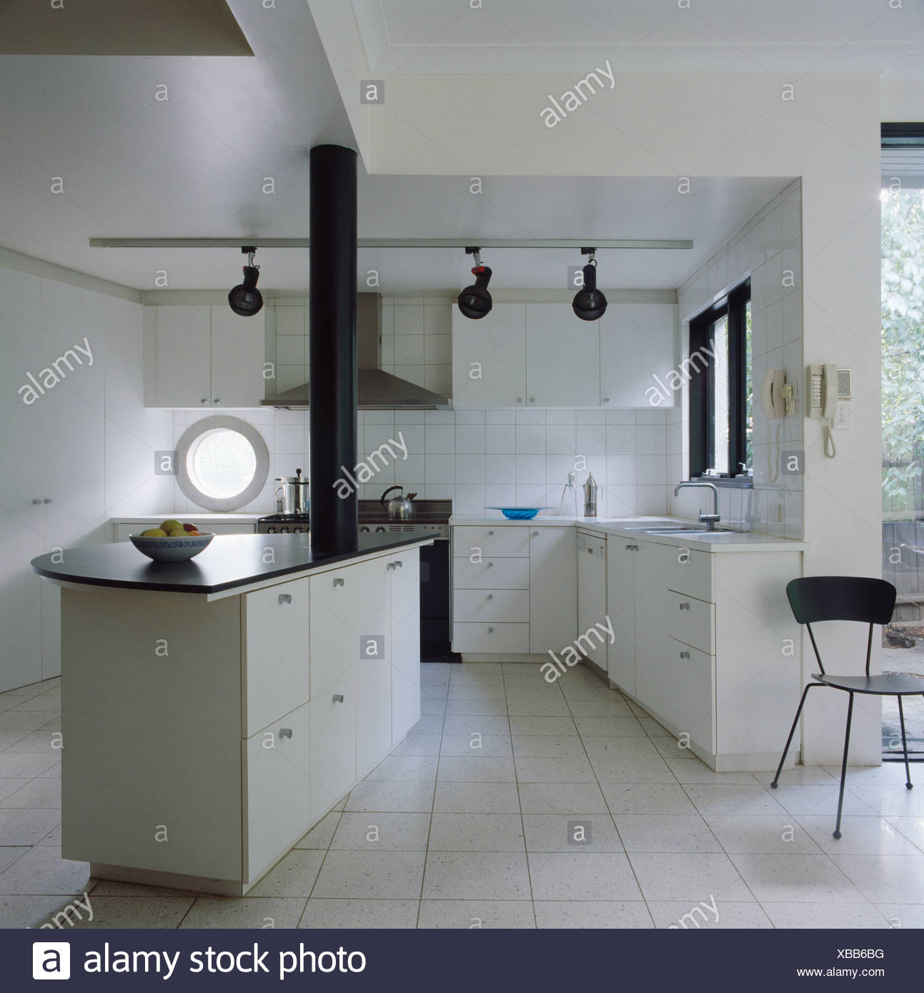 White Ceramic Tiled Floor In Modern White Kitchen With Island Unit Stock Photo Alamy