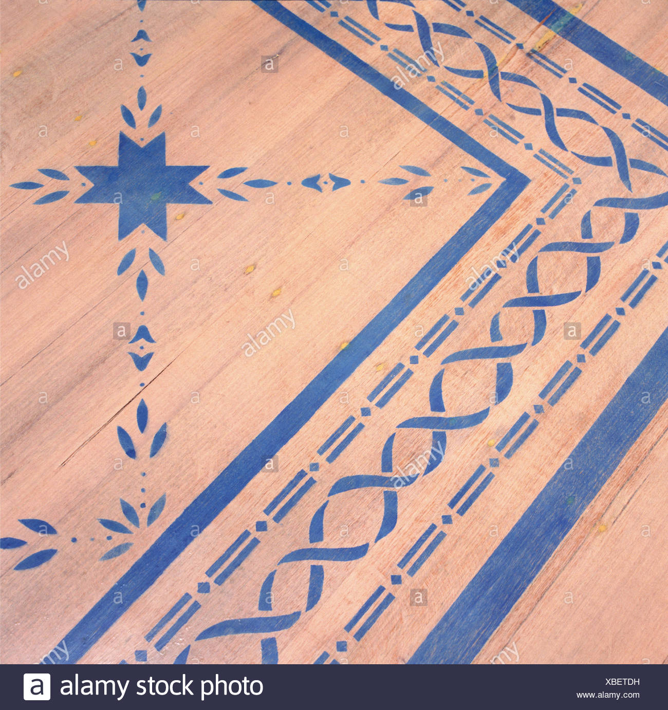 Close Up Of Wooden Floor With Blue Stenciled Pattern Stock Photo