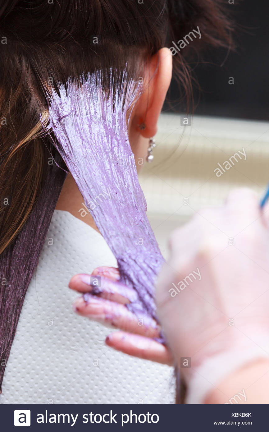 Professional Female Hairdresser Applying Color To Female Customer