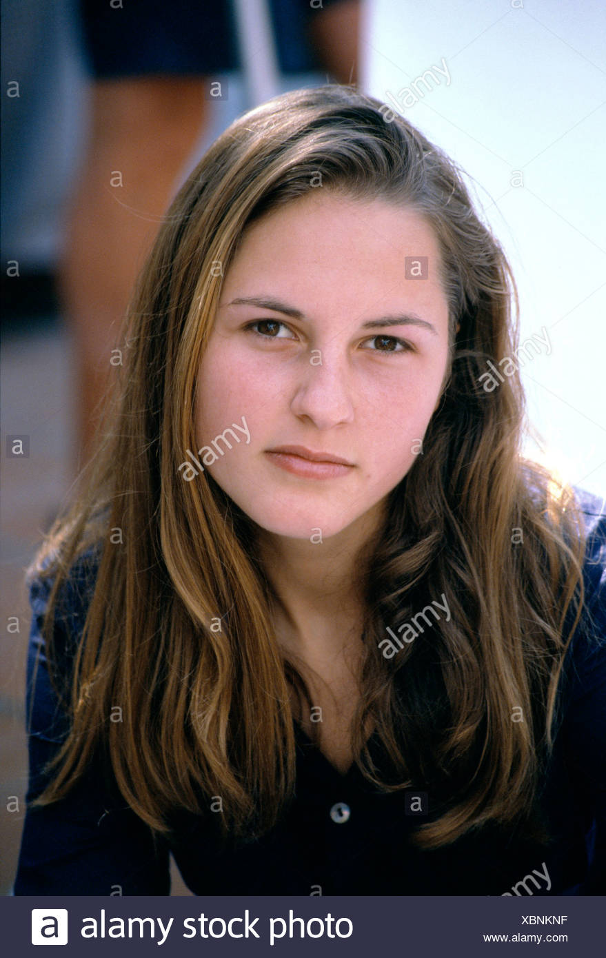Female With Long Brunette Hair In Side Parting Wearing Dark Blue