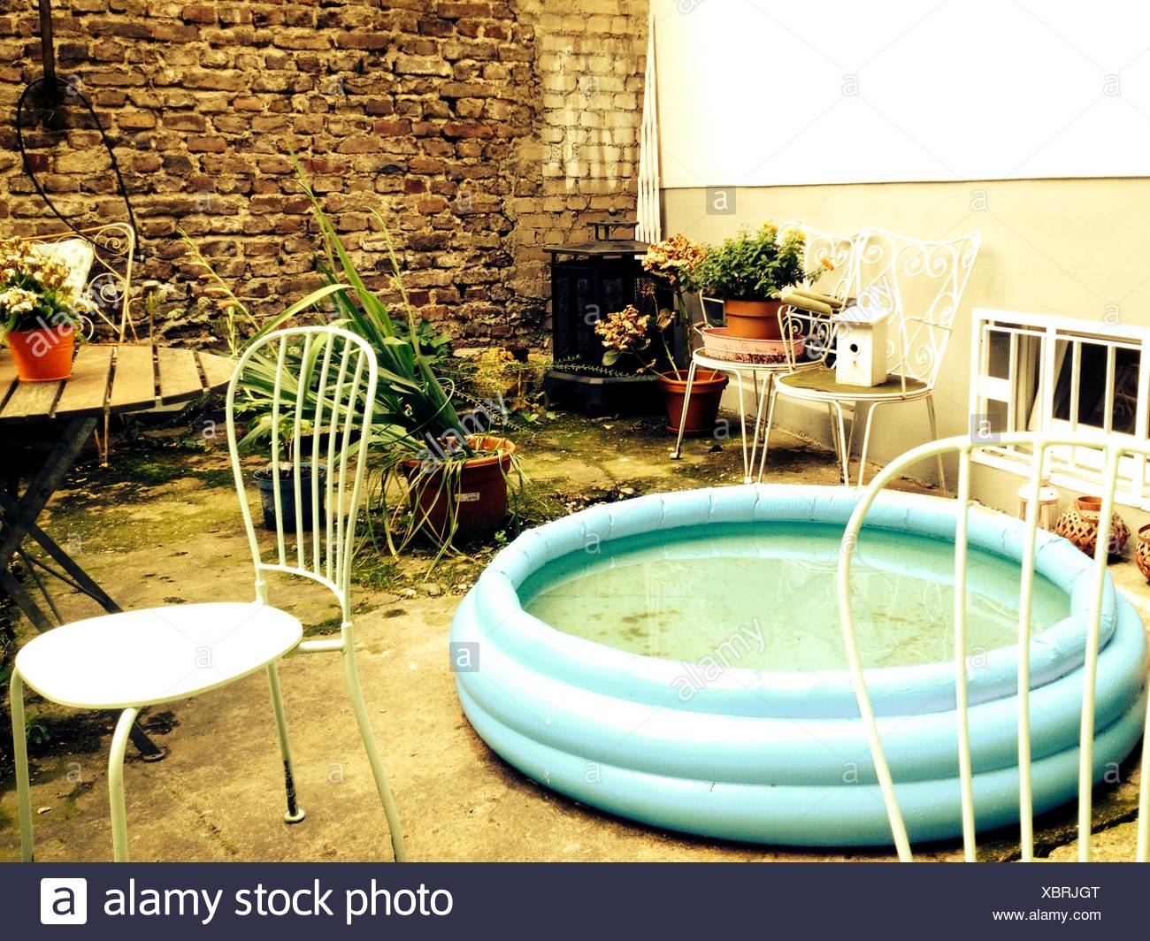 Wading Pool And Chairs Abandoned On Backyard Stock Photo