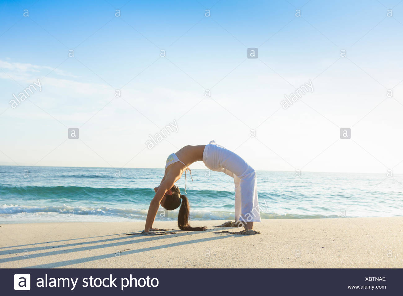 Woman Doing Wheel Yoga Pose On The Beach High Resolution Stock Woman Doing Wheel Yoga Pose On The Beach High Resolution Stock