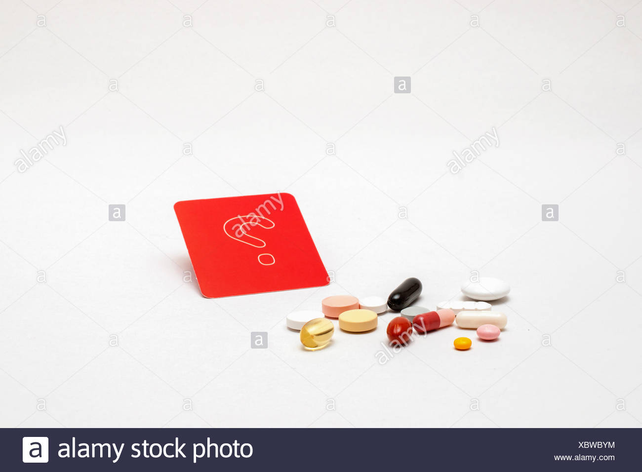 verschiedene bunte Tabletten mit rotem Fragezeichen-Schild, isoliert Stock Photo
