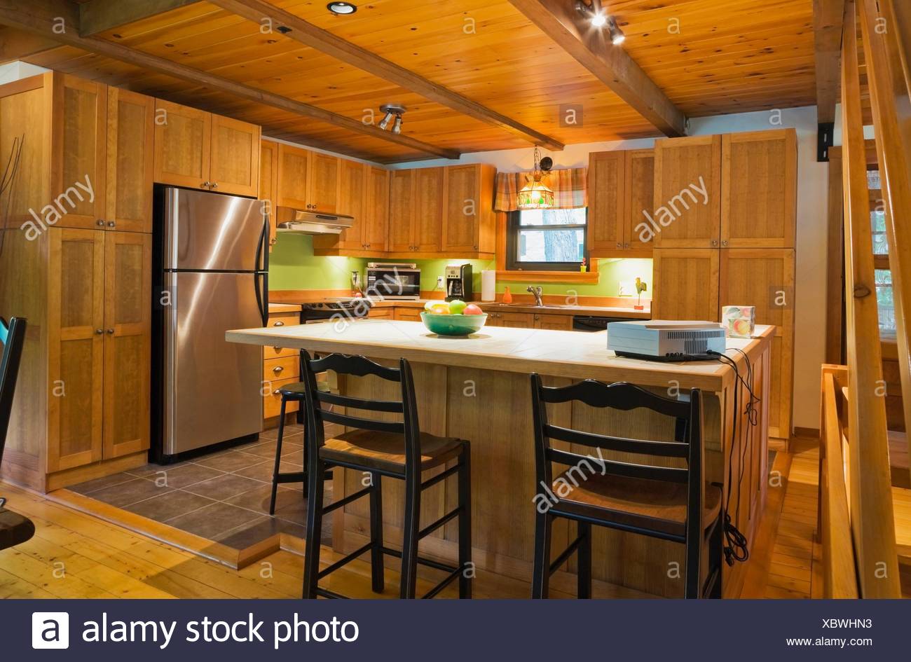 Wooden Kitchen Island With Ceramic Counter In Canadian Cottage
