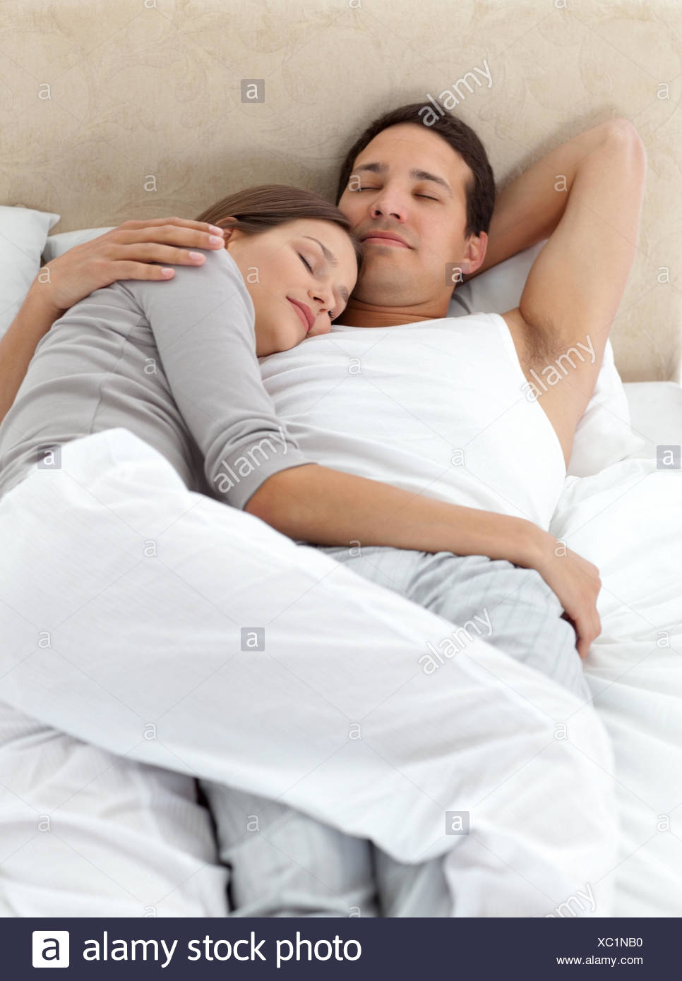 Cute Couple Sleeping In Each Other S Arms On Their Bed Stock