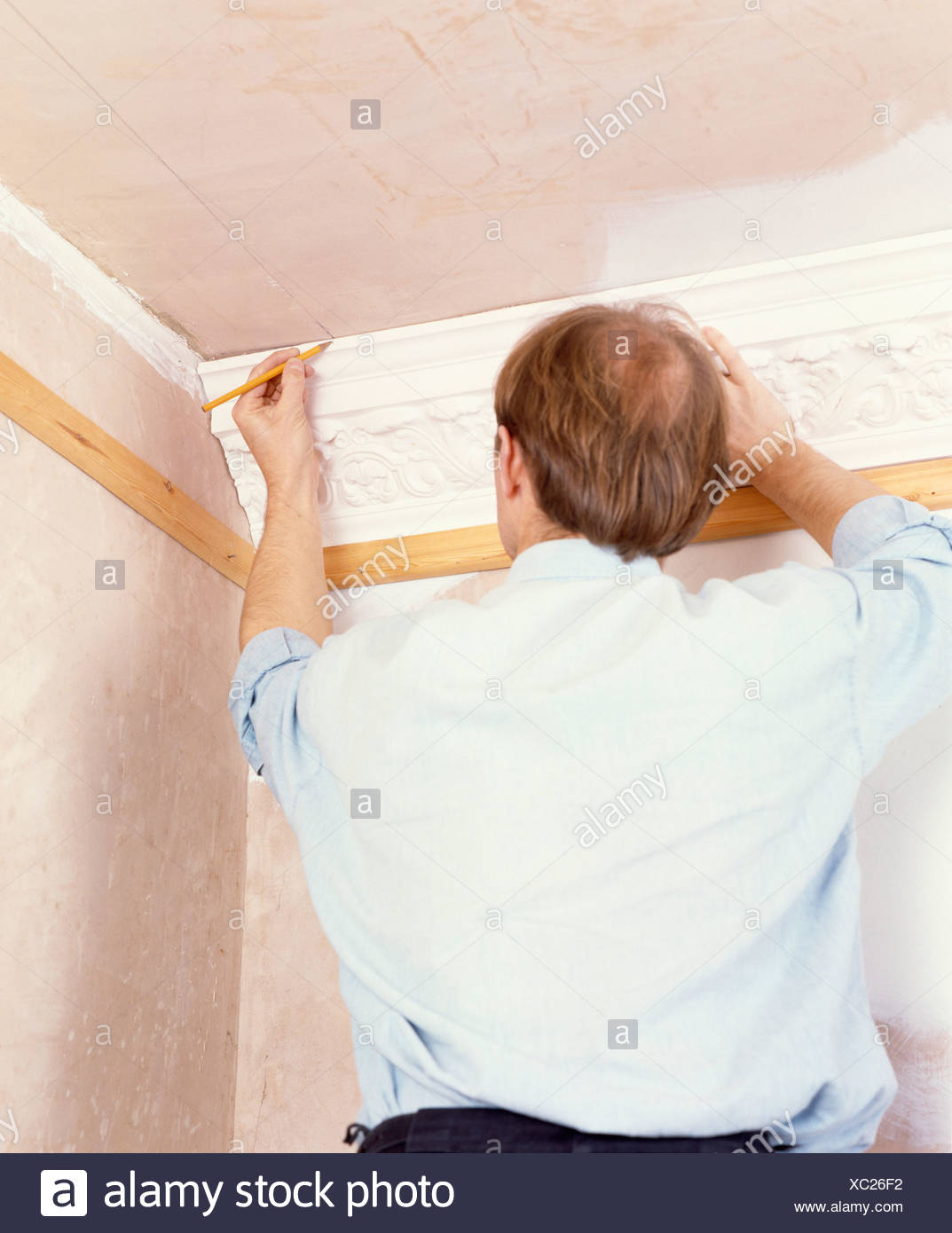 Close Up Of Man Repairing Plaster Ceiling Cornice Stock