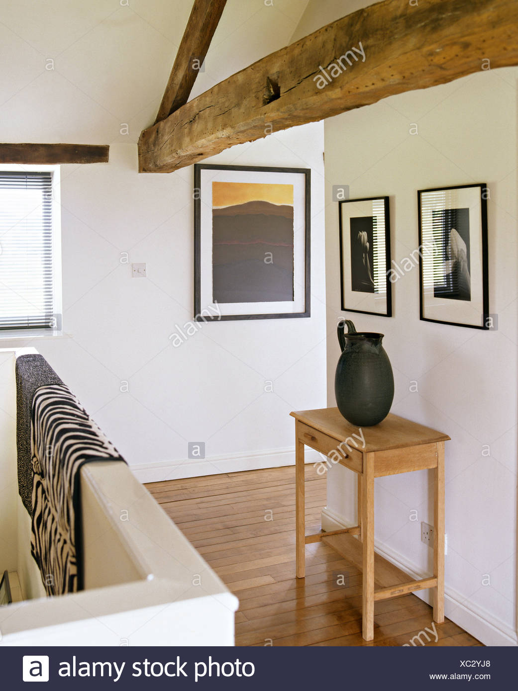 Black White Framed Photographs On Wall Above Black Jug On
