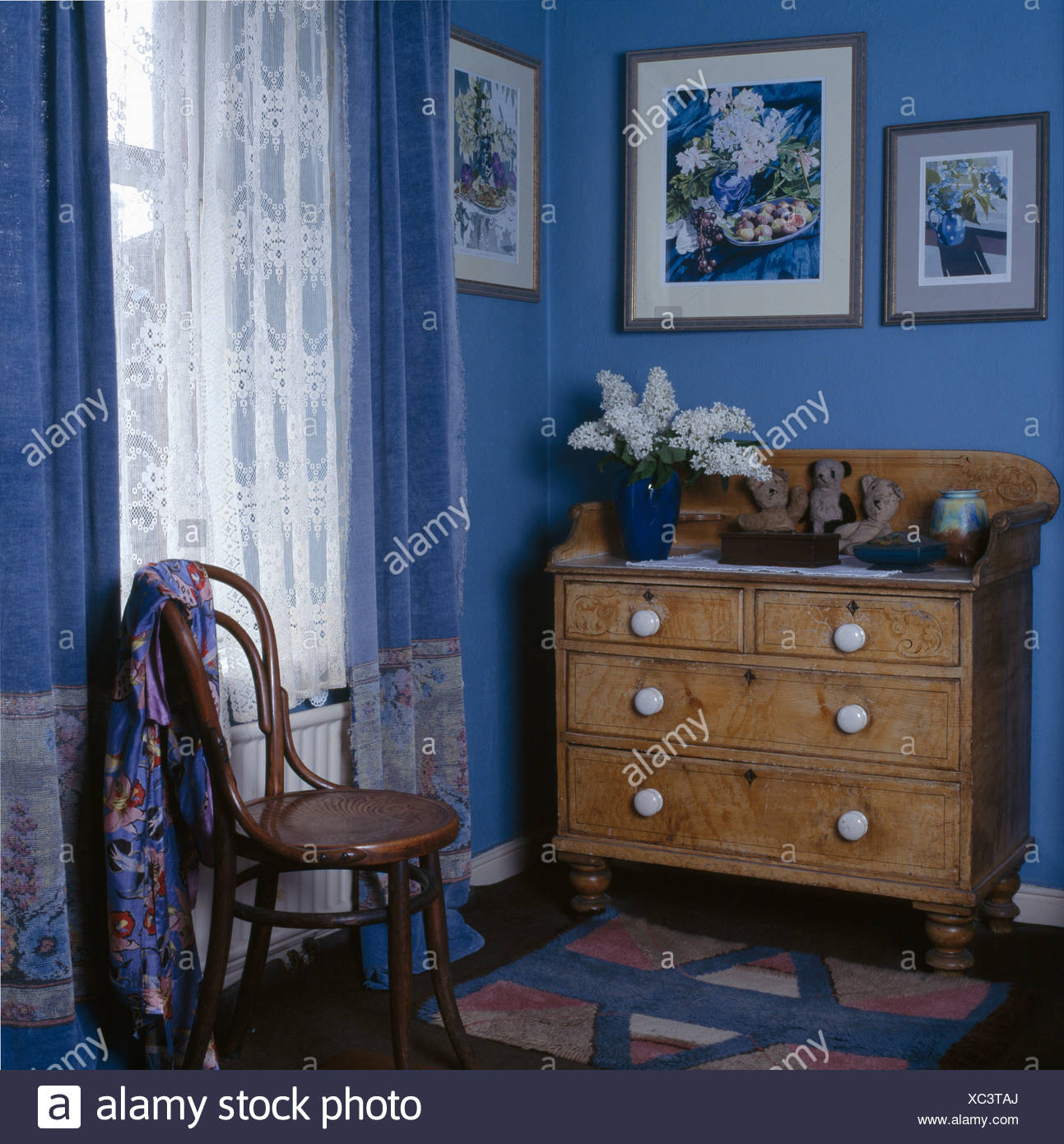 Decorated Pine Chest Of Drawers In Small Blue Bedroom With