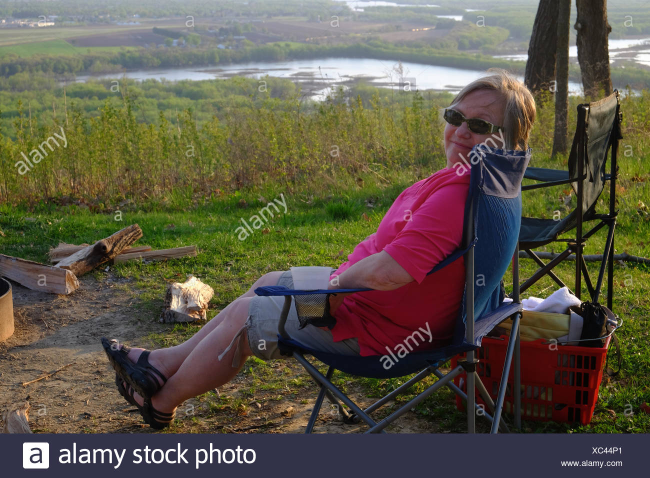 A Woman Sits On A Camp Chair With Her Legs Out Stretched At