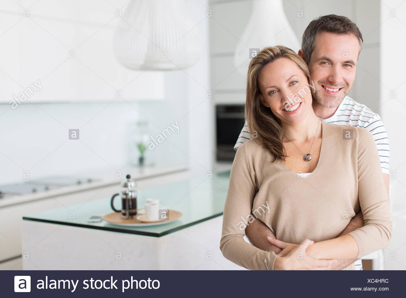 Couple hugging in modern kitchen Stock Photo