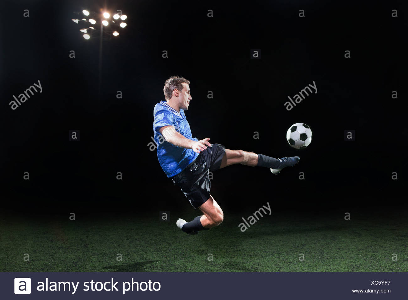 Mixed Race Man Kicking Soccer Ball Stock Photos & Mixed Race Man