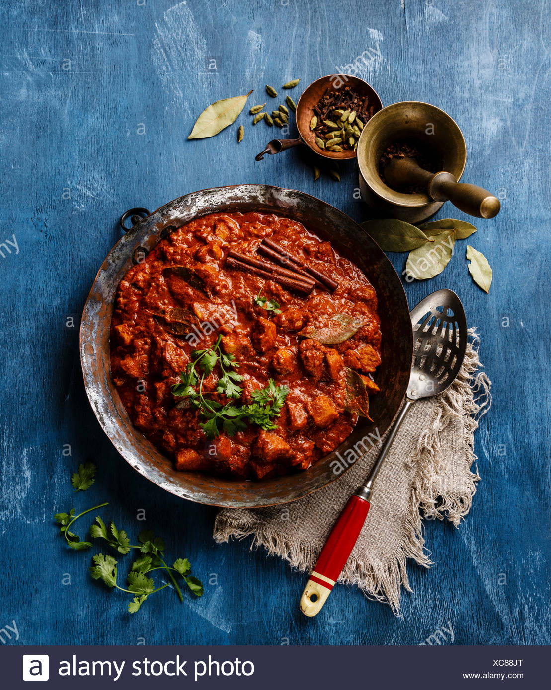 Chicken Tikka Masala Spicy Indian Curry In A Copper Pan On Blue