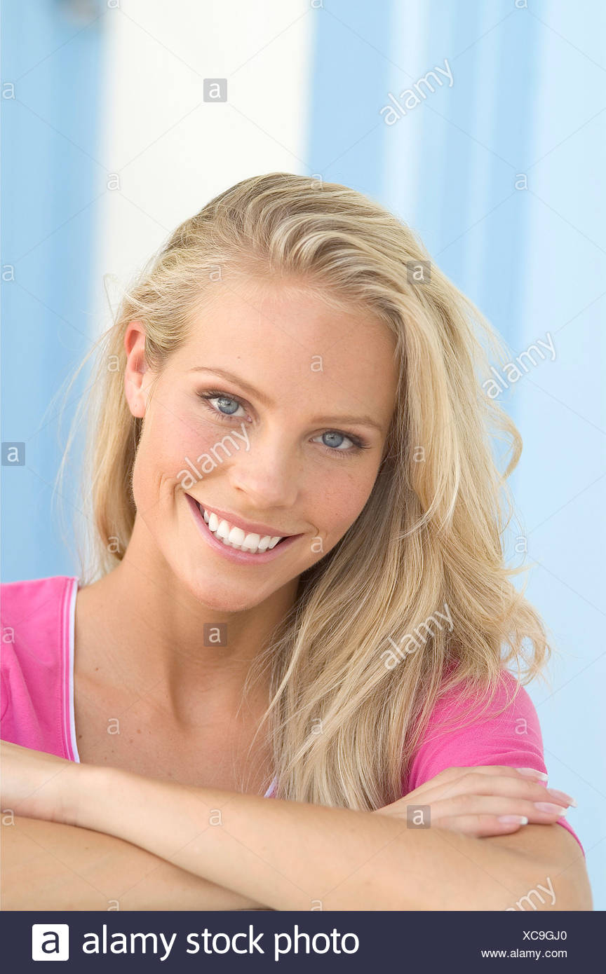 Blonde Female Long Wavy Hair Swept To The Side Wearing A Pink T
