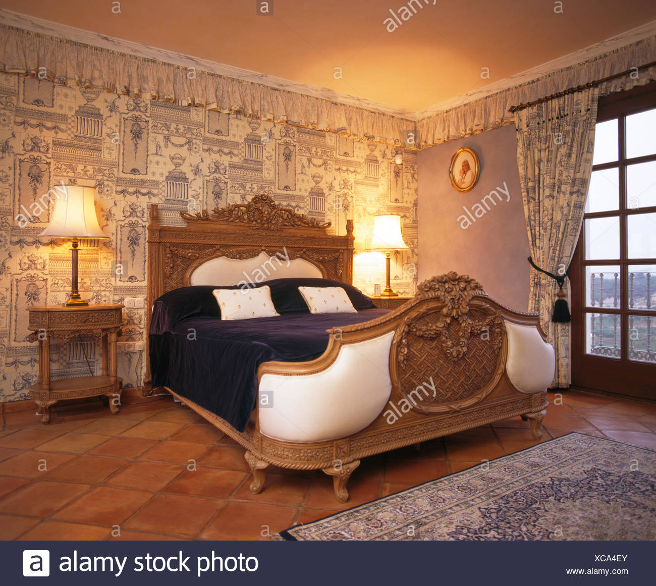 Ornate Carved Wooden Bed In Spanish Bedroom With Print Room