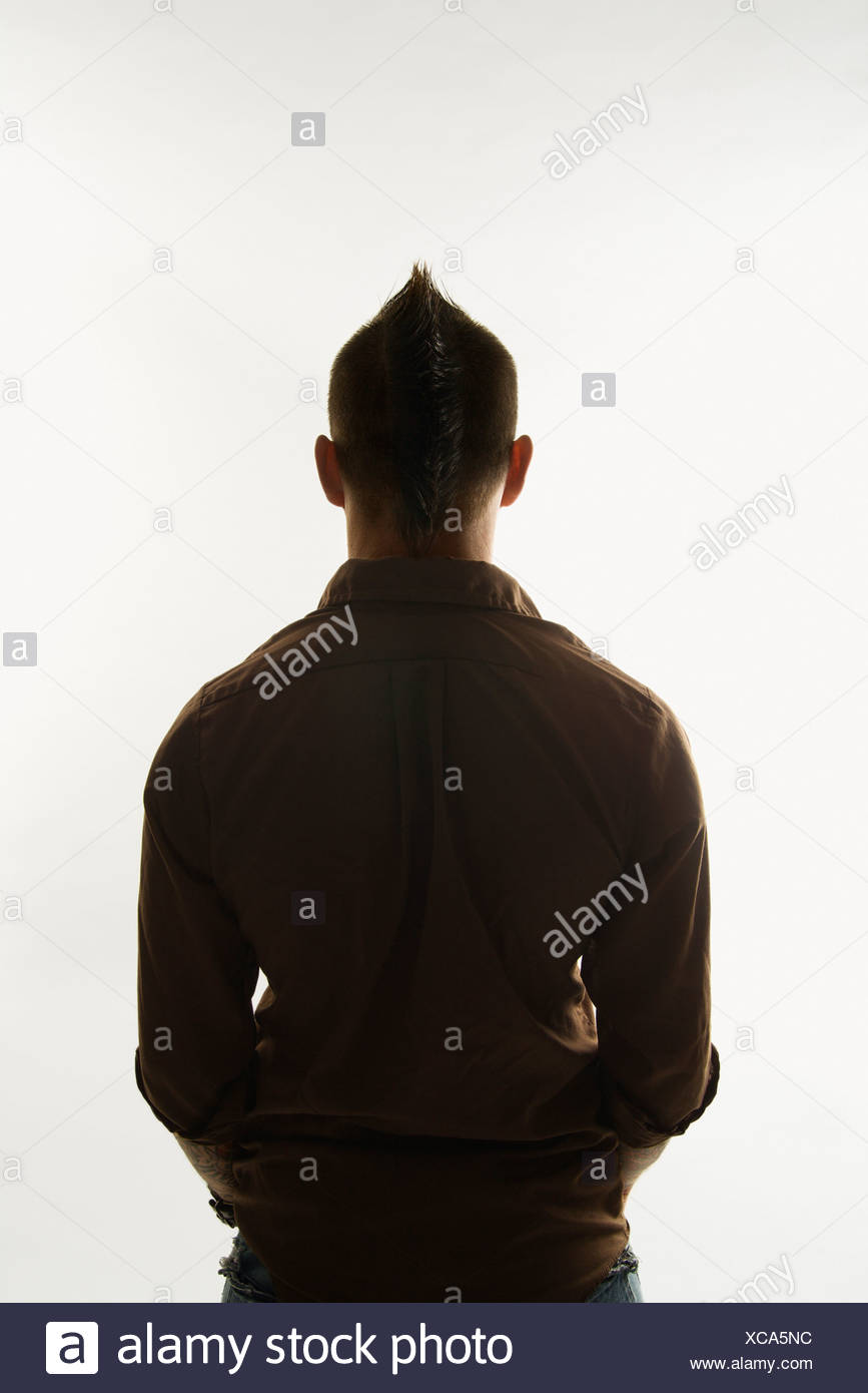 Rear View Of Caucasian Man With Mohawk Standing Against White