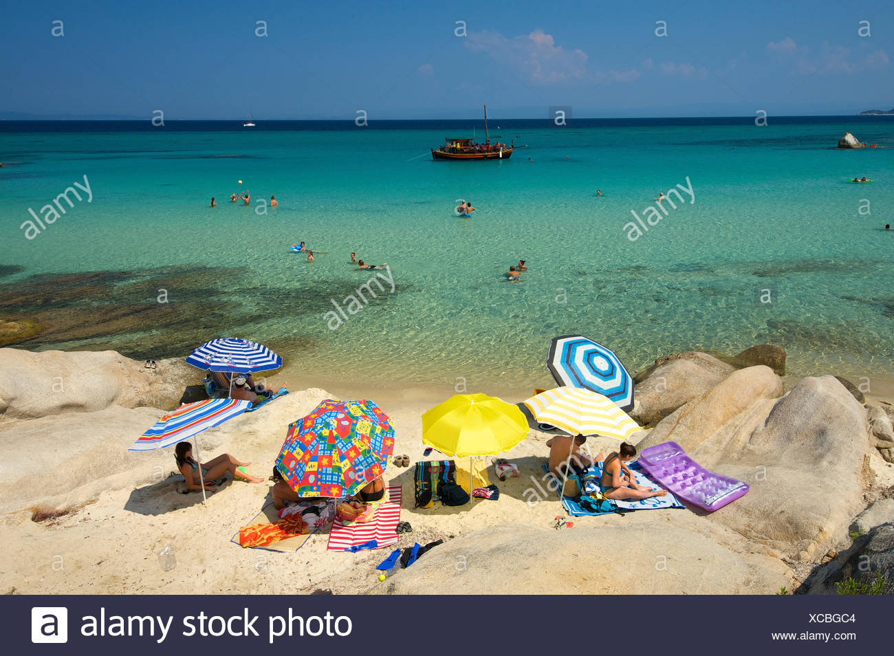 Tourists with parasols at the beach of Portokali, Kavourotypes, Sithonia, Chalkidiki or Halkidiki, Greece, Europe Stock Photo