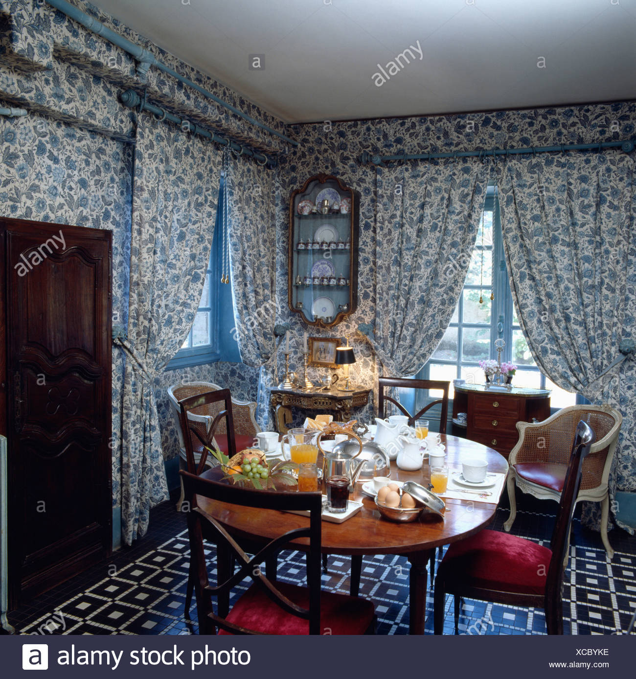 Matching Blue Floral Patterned Wallpaper And Curtains In Traditional Dining Room With Antique Furniture Patterned Flooring Stock Photo Alamy