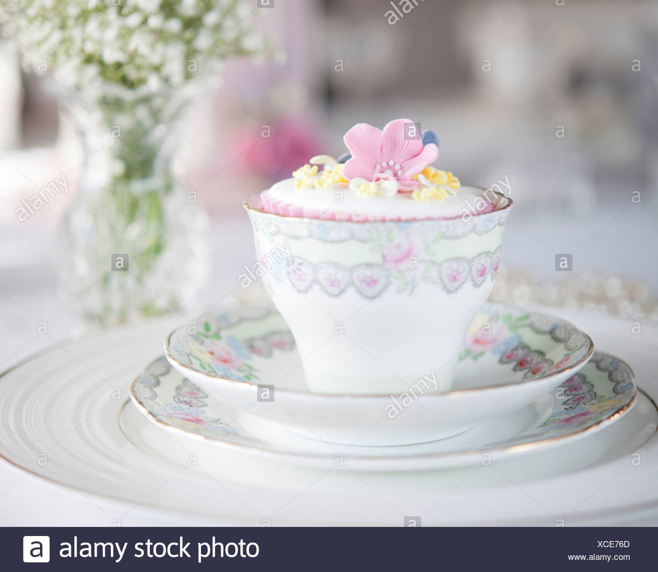 A Floral China Cup Saucer And Plates With Iced Cupcake And Vase
