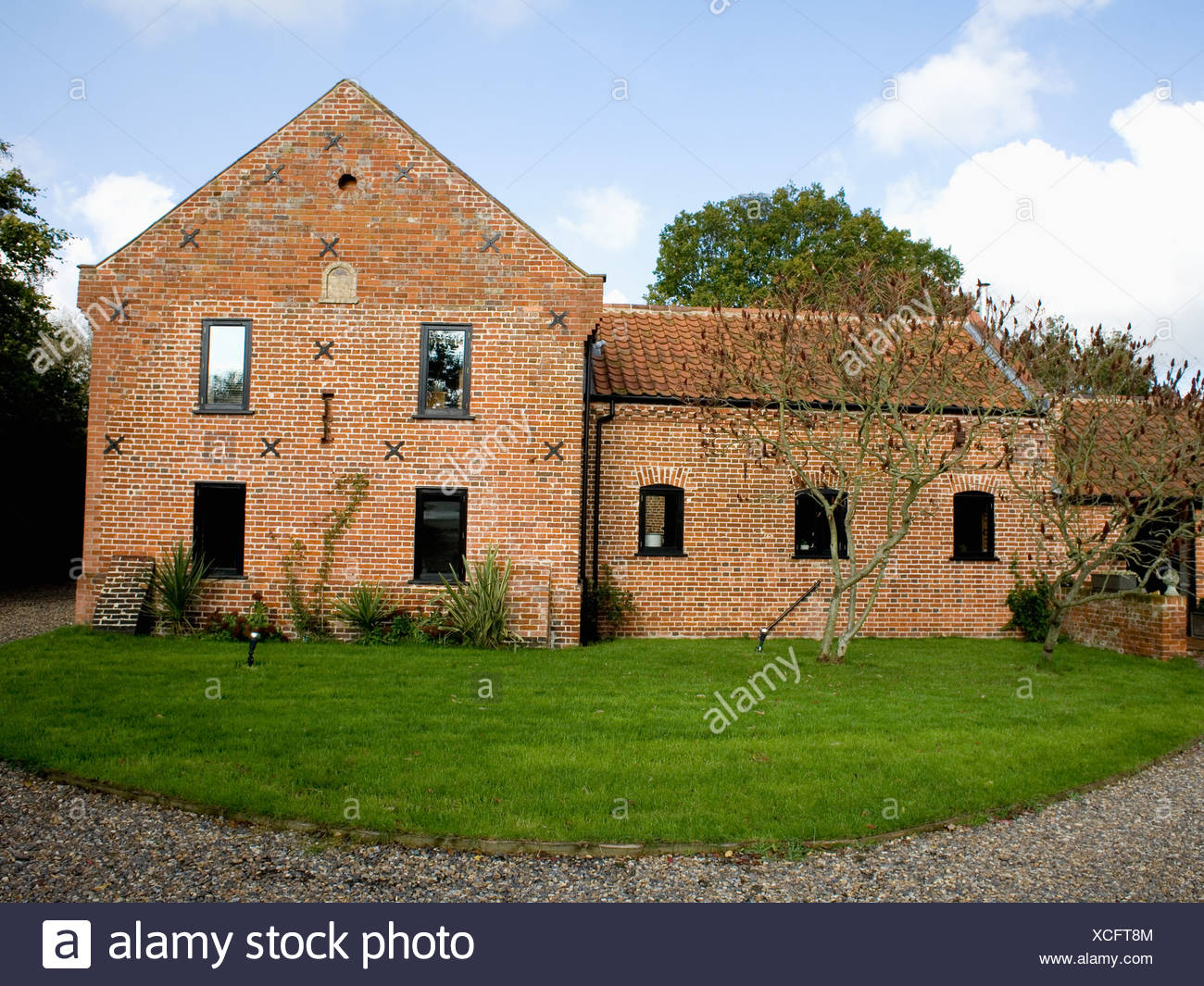 Lawn In Front Of Traditional Brick Built Country Barn Conversion