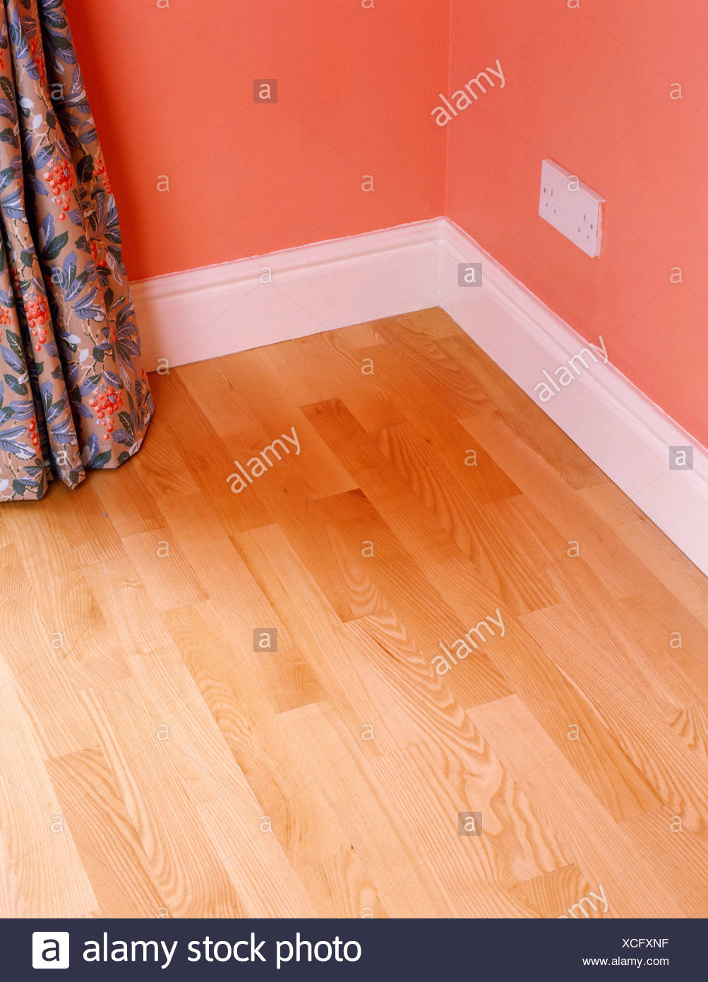 Corner Of Room With Laminate Wood Floor And White Skirting Board