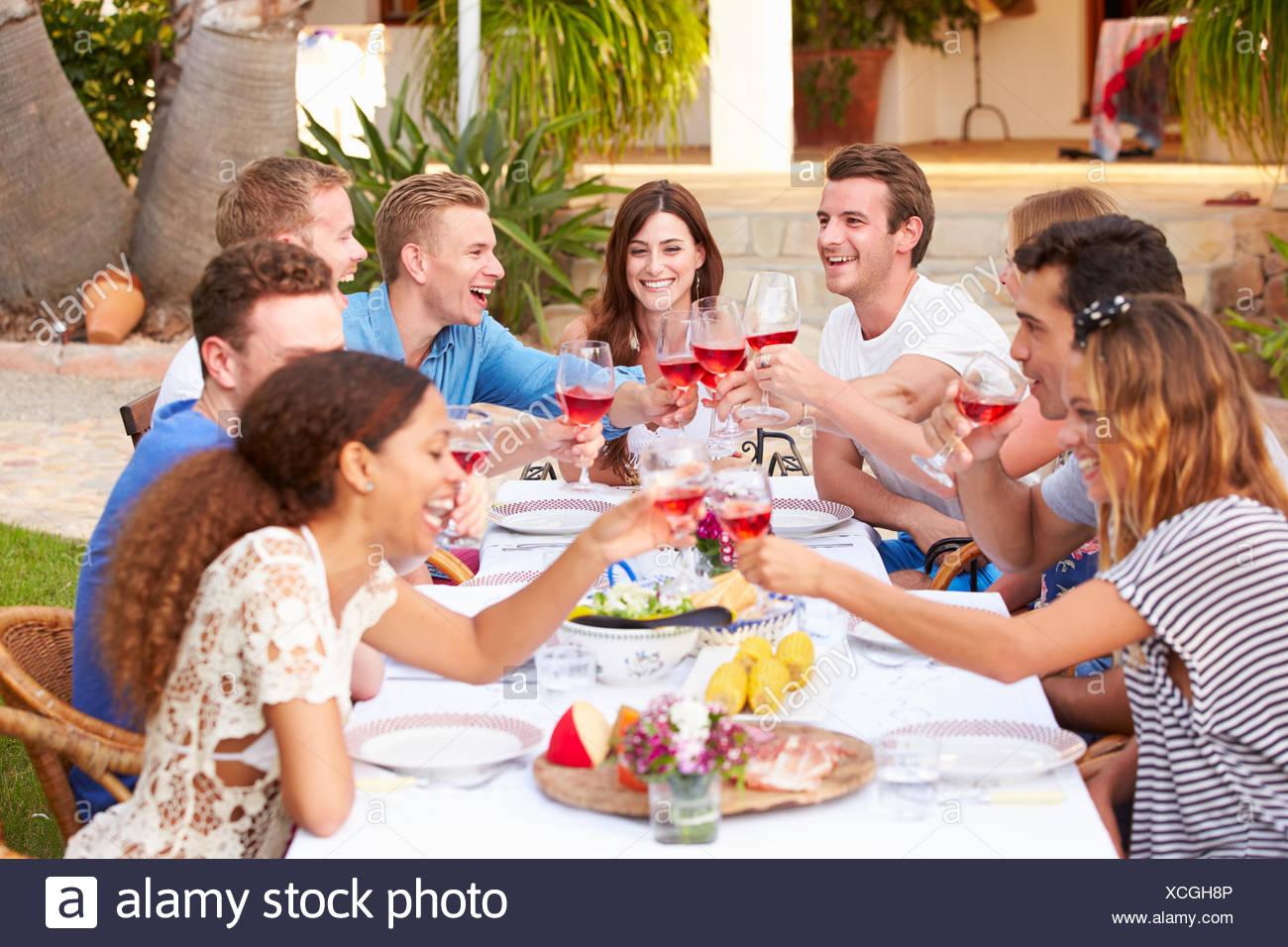 Large Group Of Young Friends Enjoying Outdoor Meal Together Stock Photo