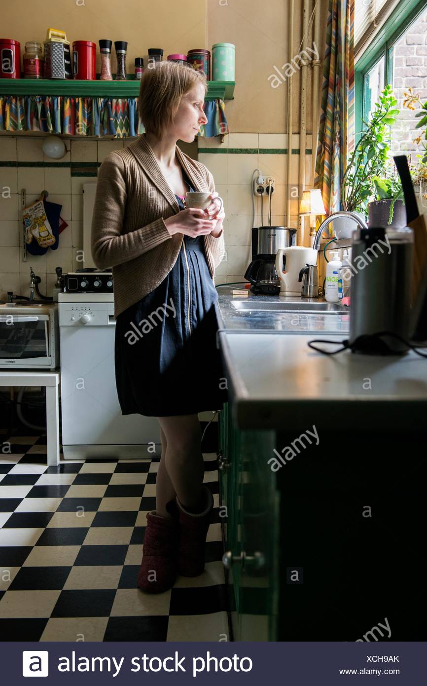 Tilburg Netherlands Adult Caucasian Woman Drinking A Cup Of Tea While Leaning Against A Vintage Kitchen Sink Stock Photo Alamy