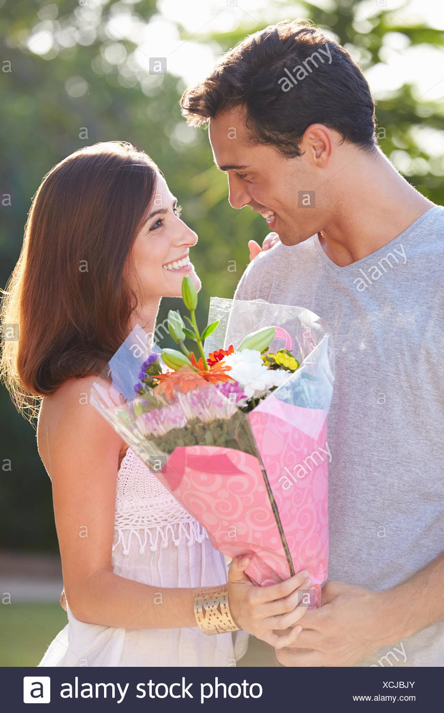 Man Giving Flowers To Woman High Resolution Stock Photography and