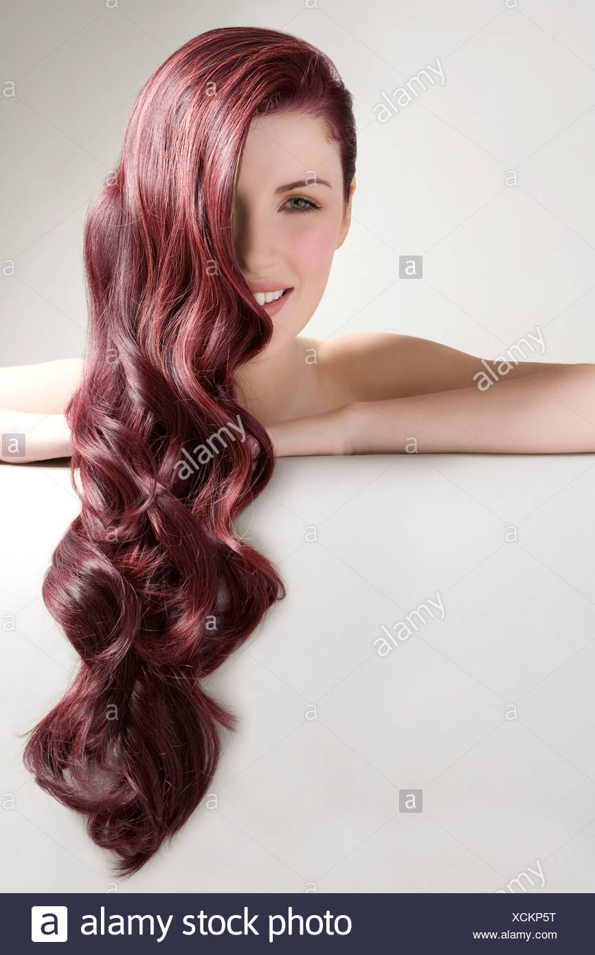 Beautiful Woman With Long Red Dyed Hair Against Gray Background