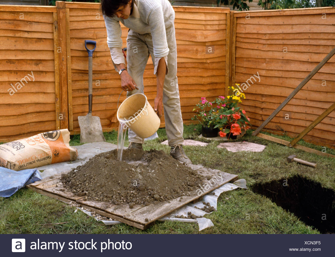 Gardener Mixing Cement Before Laying Paved Patio In A New Garden For Editorial Use Only Stock Photo Alamy