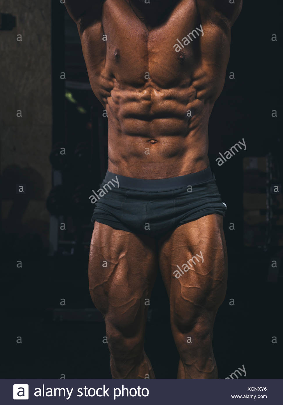 Torso and legs of a muscular bodybuilder posing in gym Stock Photo ...